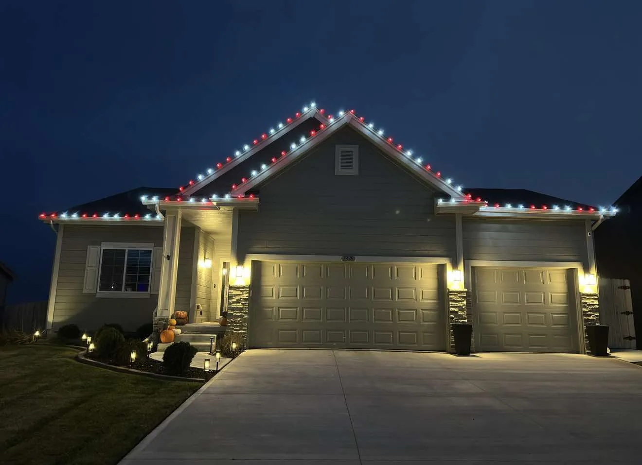 Multicolour holiday lights following a steep gable and porch