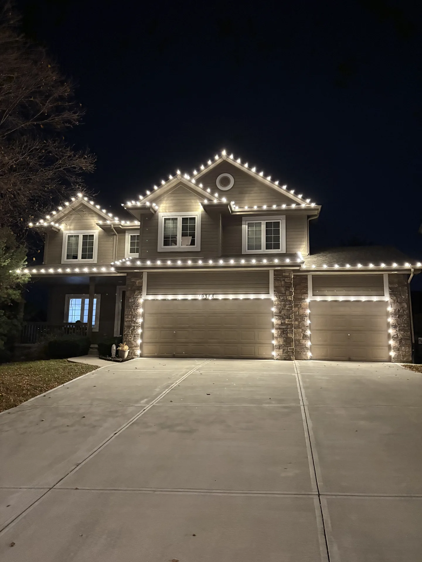 Roofline and peak lighting installed by Let There Be Light on a brick home in Omaha, Nebraska — with the display glowing warm