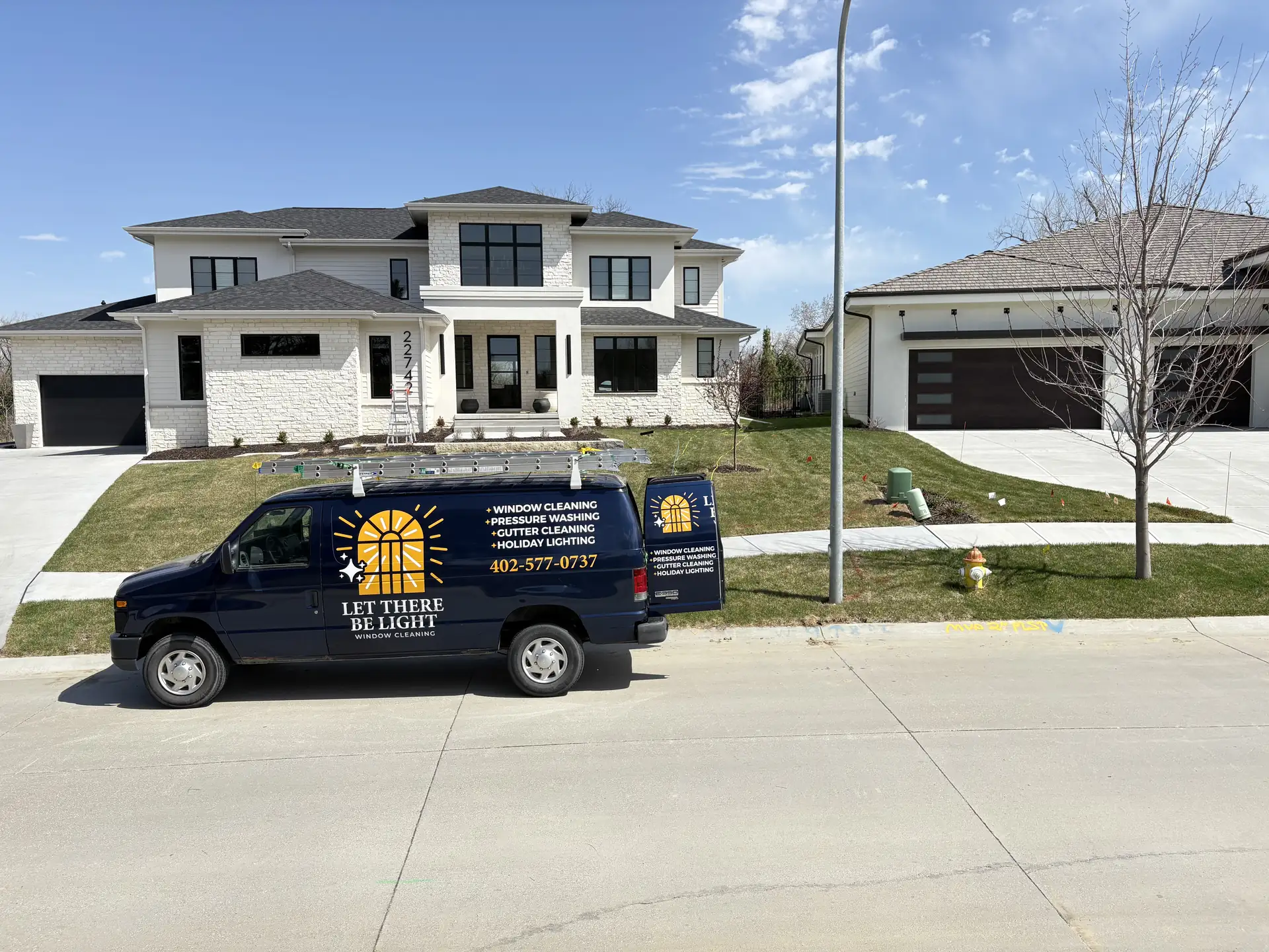 Let There Be Light Window Cleaning branded van parked in the driveway of an Omaha home