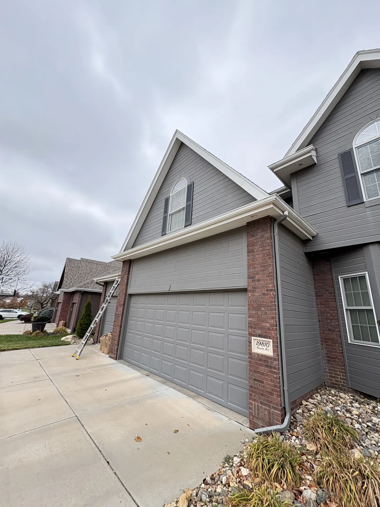 Daytime holiday lighting installation in progress at an Omaha home
