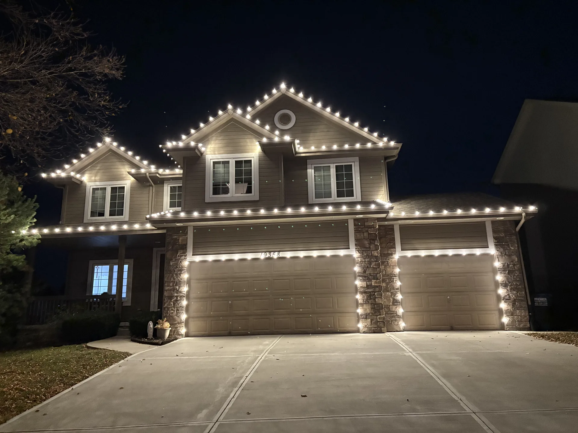 Warm white holiday lights following every peak and gable of a family home