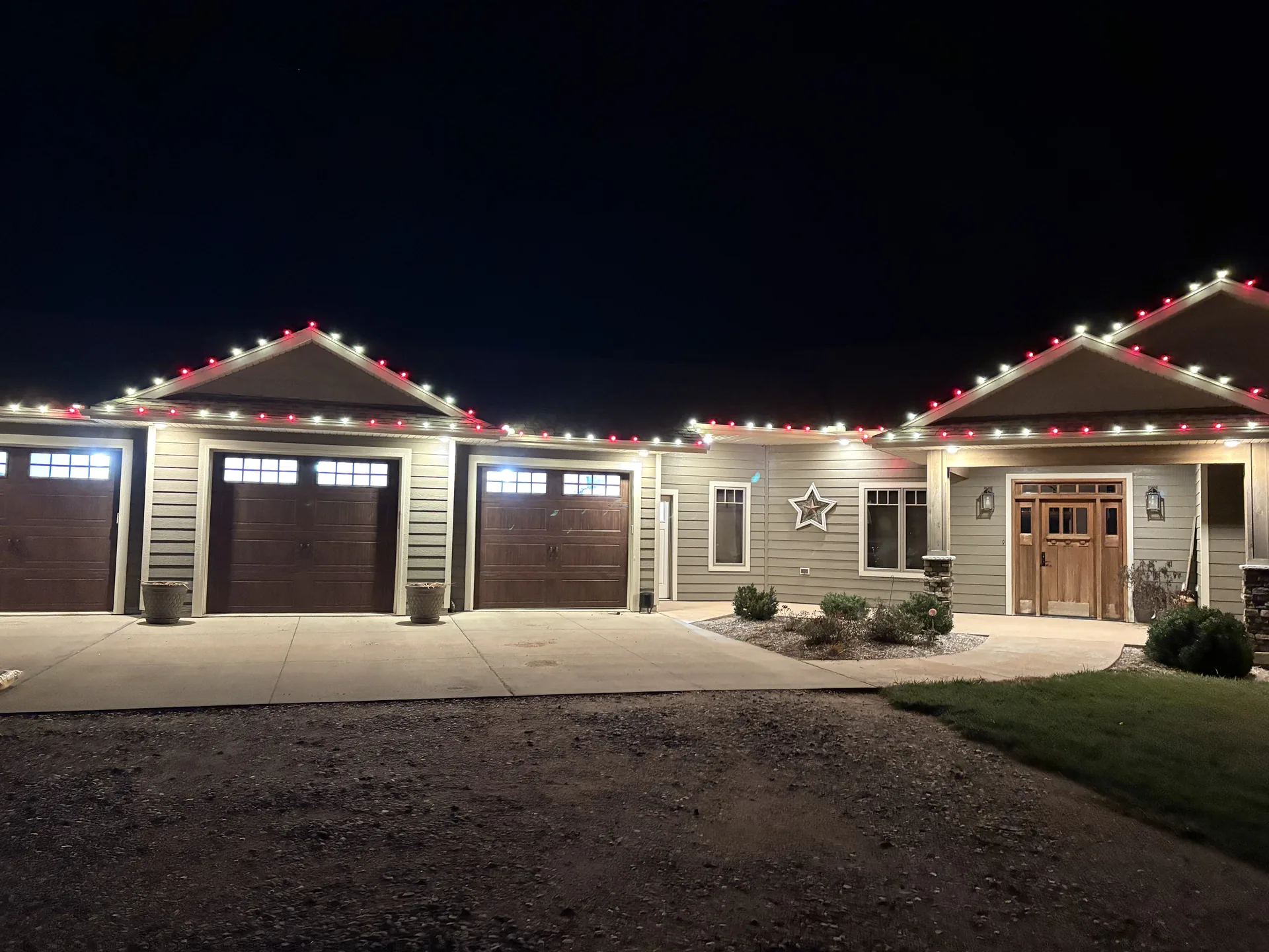 Finished holiday lighting installation glowing at dusk