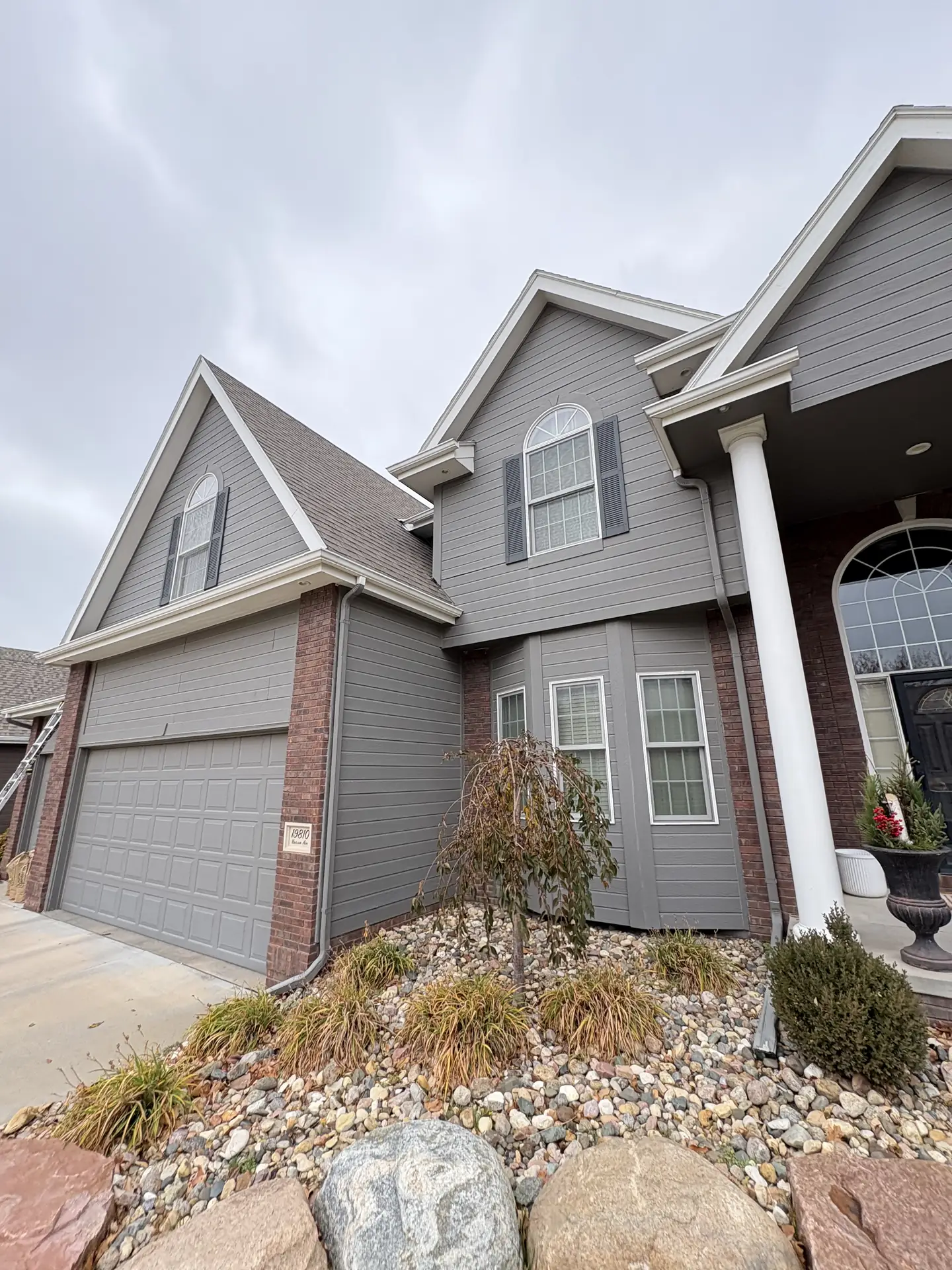 Pure-water pole system rinsing upper-story glass on a modern build in Omaha, Nebraska — with tracks and sills detailed