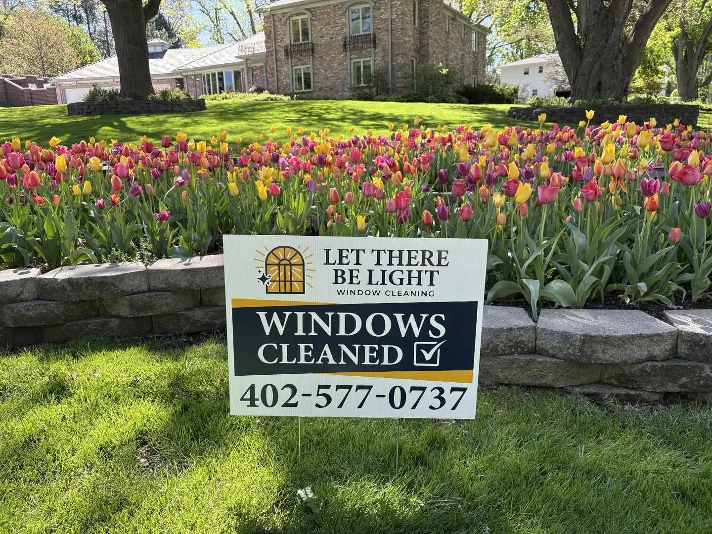 Let There Be Light yard sign in front of a freshly serviced home