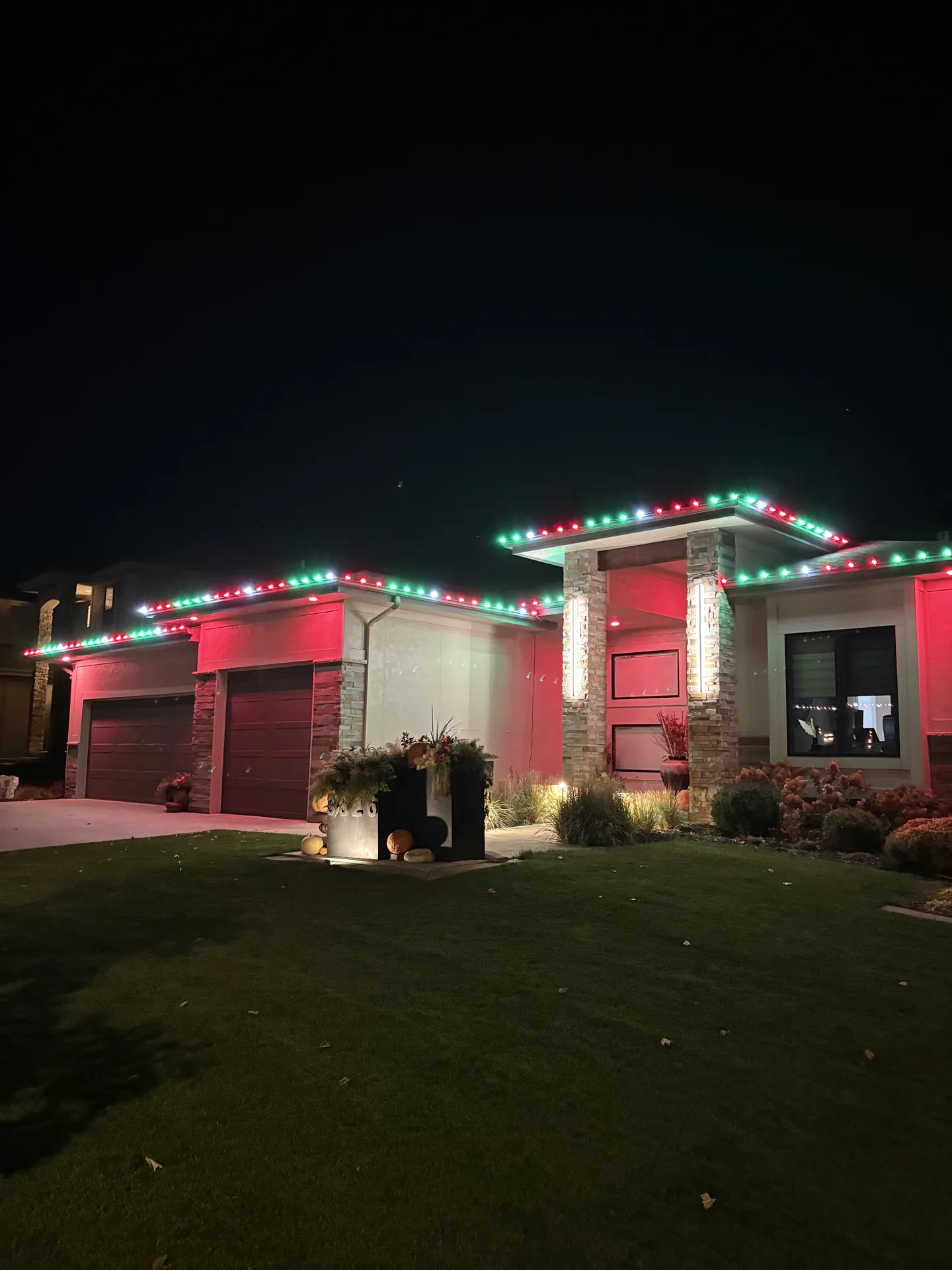 Red and green holiday lights lining a contemporary rooftop